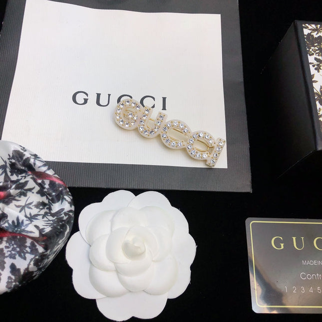 GUCCI 26S CRYSTAL EMBELLISHED SCRIPT LOGO STATEMENT BROOCH IN GOLD TONE METAL 629881