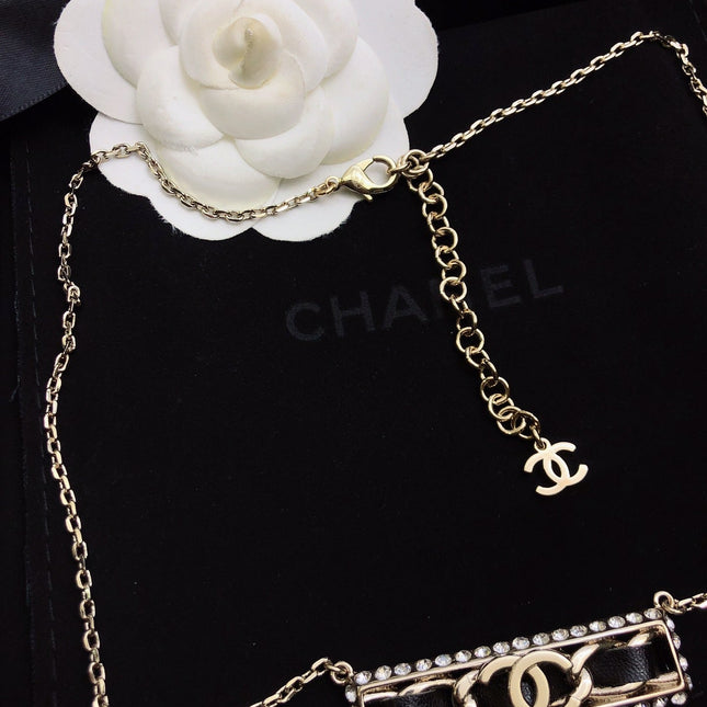 CHANEL 26S CHANEL CC LOGO CRYSTAL TRIM BAR PENDANT NECKLACE WITH BLACK LEATHER IN GOLD METAL 633315