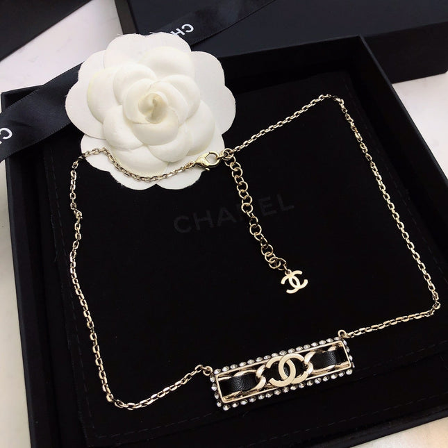 CHANEL 26S CHANEL CC LOGO CRYSTAL TRIM BAR PENDANT NECKLACE WITH BLACK LEATHER IN GOLD METAL 633315