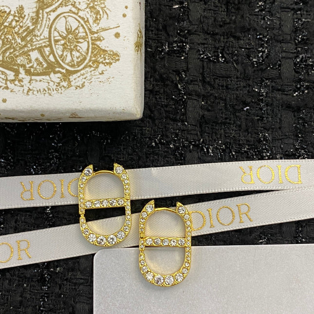CD 26S CRYSTAL LOGO STUD EARRINGS IN GOLD TONE METAL 646502