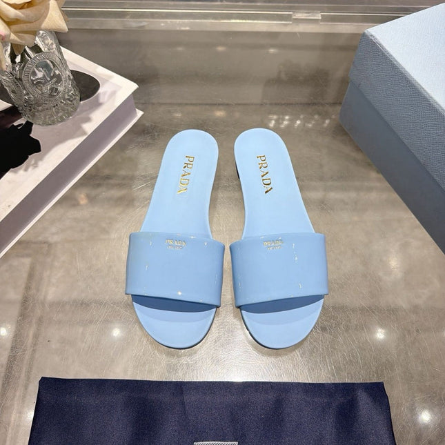 PRADA 26S LOGO EMBOSSED SLIDE SANDALS IN SKY BLUE PATENT CALFSKIN