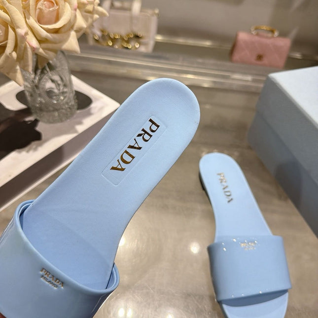 PRADA 26S LOGO EMBOSSED SLIDE SANDALS IN SKY BLUE PATENT CALFSKIN
