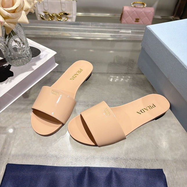 PRADA 26S LOGO EMBOSSED SLIDE SANDALS IN NUDE BEIGE PATENT CALFSKIN