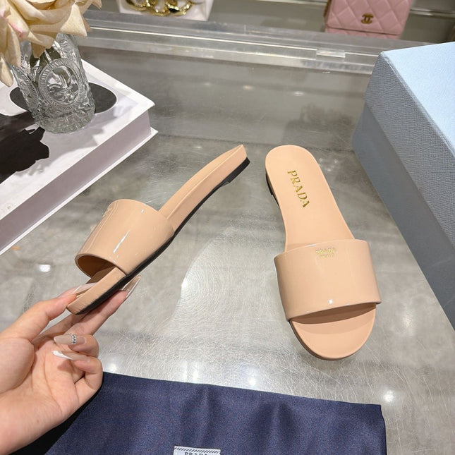 PRADA 26S LOGO EMBOSSED SLIDE SANDALS IN NUDE BEIGE PATENT CALFSKIN