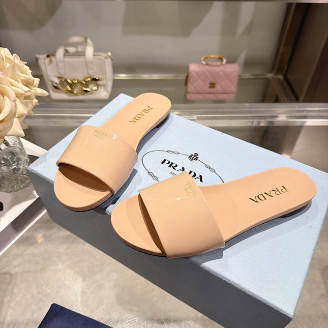 PRADA 26S LOGO EMBOSSED SLIDE SANDALS IN NUDE BEIGE PATENT CALFSKIN