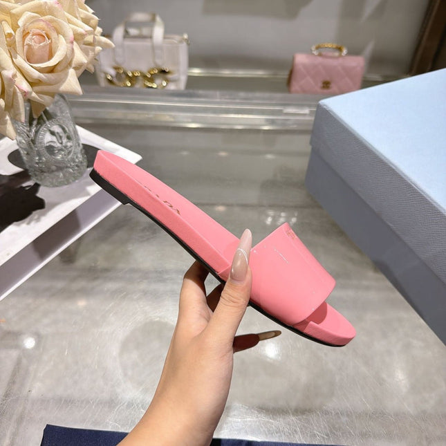 PRADA 26S LOGO EMBOSSED SLIDE SANDALS IN PINK PATENT CALFSKIN