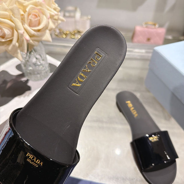 PRADA 26S LOGO EMBOSSED SLIDE SANDALS IN BLACK PATENT CALFSKIN