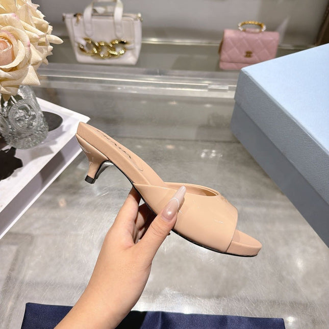 PRADA 26S LOGO EMBOSSED KITTEN HEEL MULES IN NUDE BEIGE PATENT CALFSKIN