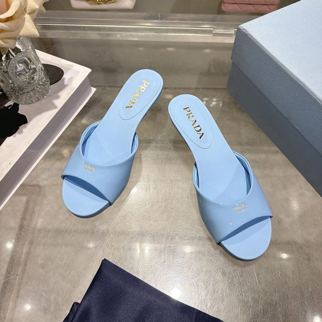 PRADA 26S LOGO EMBOSSED KITTEN HEEL MULES IN SKY BLUE PATENT CALFSKIN