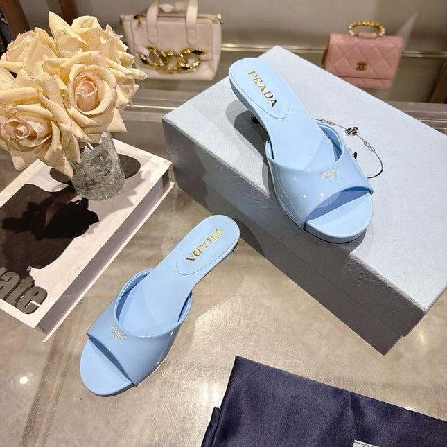 PRADA 26S LOGO EMBOSSED KITTEN HEEL MULES IN SKY BLUE PATENT CALFSKIN
