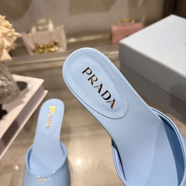 PRADA 26S LOGO EMBOSSED KITTEN HEEL MULES IN SKY BLUE PATENT CALFSKIN