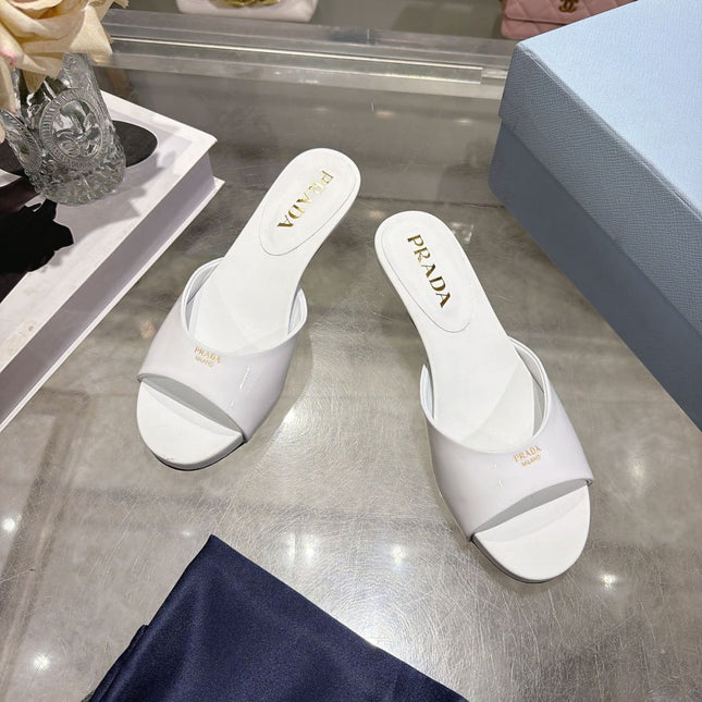 PRADA 26S LOGO EMBOSSED KITTEN HEEL MULES IN WHITE PATENT CALFSKIN