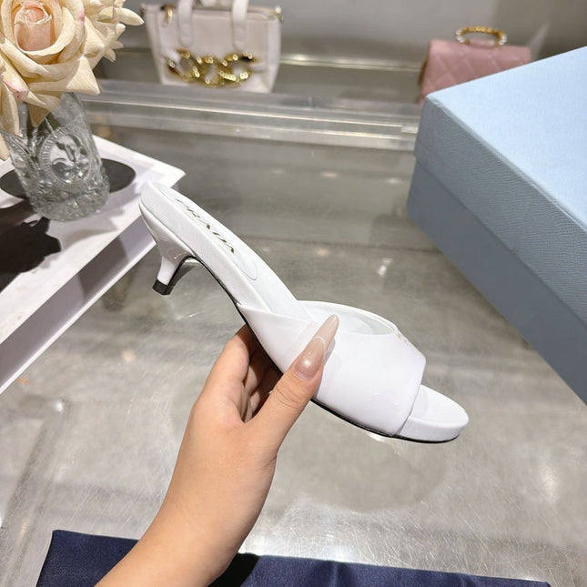 PRADA 26S LOGO EMBOSSED KITTEN HEEL MULES IN WHITE PATENT CALFSKIN