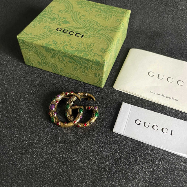 GUCCI 26S INTERLOCKING G MULTICOLOR GEM LOGO BROOCH IN ANTIQUE GOLD TONE METAL 625634
