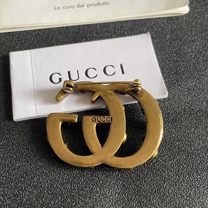 GUCCI 26S INTERLOCKING G MULTICOLOR GEM LOGO BROOCH IN ANTIQUE GOLD TONE METAL 625634