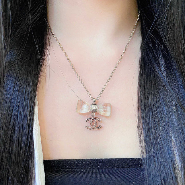 CHANEL 26S DOUBLE C LOGO CLEAR BOW PENDANT NECKLACE IN GOLD METAL 629174