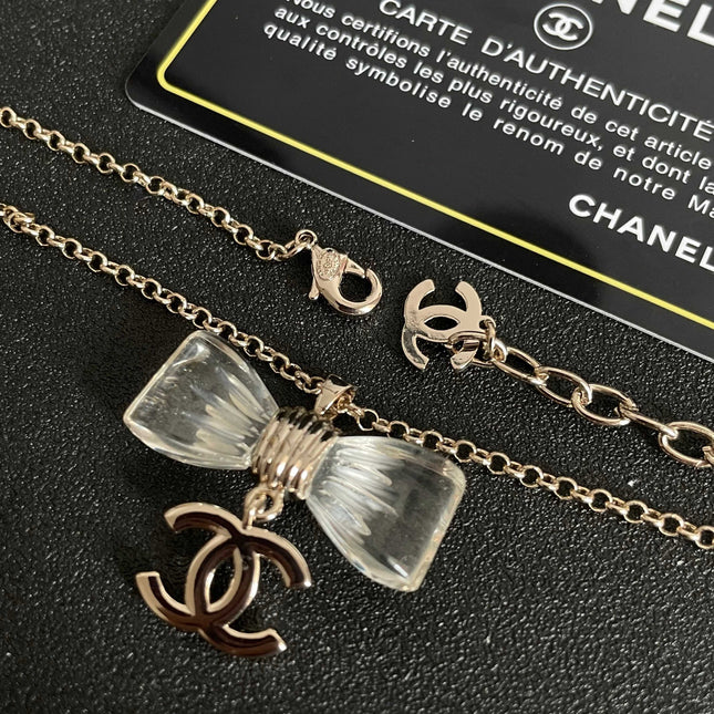 CHANEL 26S DOUBLE C LOGO CLEAR BOW PENDANT NECKLACE IN GOLD METAL 629174