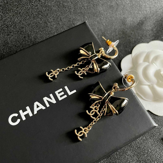 CHANEL 26S DOUBLE C LOGO BLACK ENAMEL BOW DANGLE EARRINGS WITH CHAIN CHARMS IN GOLD METAL 629178