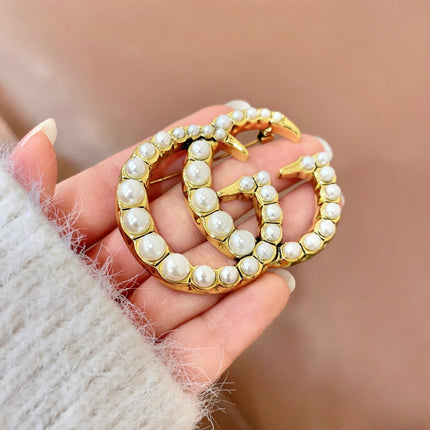 GUCCI 26S DOUBLE G LOGO PEARL EMBELLISHED STATEMENT BROOCH IN GOLD TONE METAL 631921