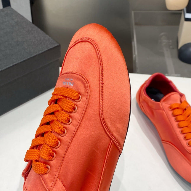 PRADA 26S SNEAKERS IN BURNT ORANGE SATIN