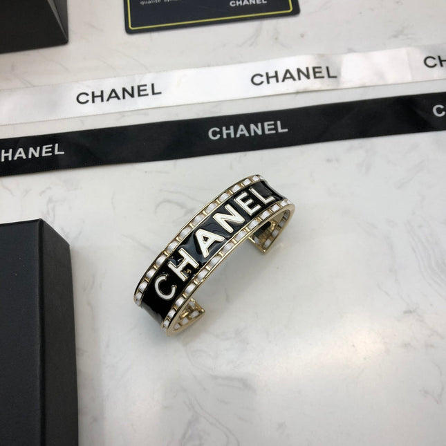 CHANEL 26S CHANEL LOGO BLACK ENAMEL STATEMENT CUFF BRACELET IN GOLD METAL 630834