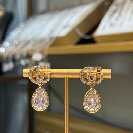 GUCCI 26S INTERLOCKING GG CRYSTAL TEARDROP EARRINGS IN GOLD TONE METAL 621443