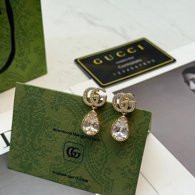 GUCCI 26S INTERLOCKING GG CRYSTAL TEARDROP EARRINGS IN GOLD TONE METAL 621443