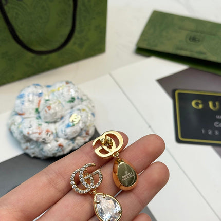GUCCI 26S INTERLOCKING GG CRYSTAL TEARDROP EARRINGS IN GOLD TONE METAL 621443