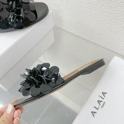 ALAIA FLAT MULE IN BLACK GLOSSY LAMBSKIN