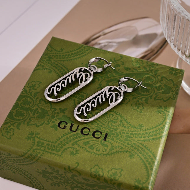 GUCCI 26S SCRIPT LOGO OVAL DROP EARRINGS IN SILVER TONE METAL 633780