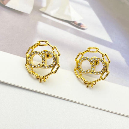 CD 26S CRYSTAL CHAIN LOGO STUD EARRINGS IN GOLD TONE METAL 645655