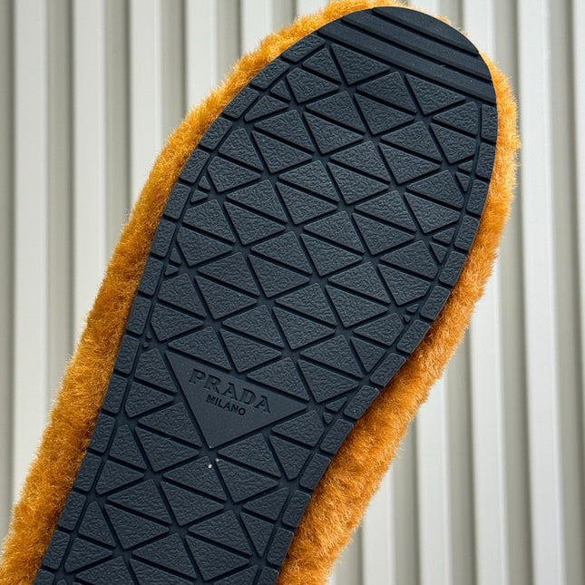 PRADA 25S CLOGS IN DARK ORANGE SHEARLING