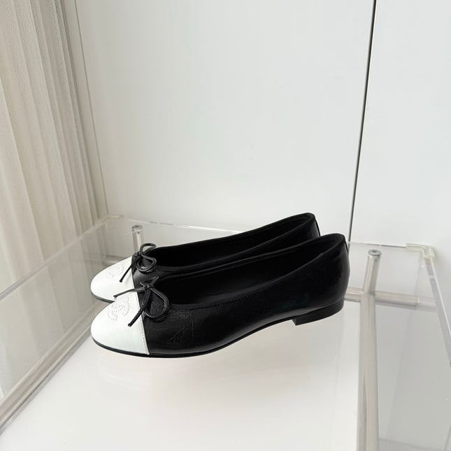 CHANEL 26S BALLET FLATS IN BLACK CRACKED CALFSKIN WITH WHITE TOE CAP AND BOW