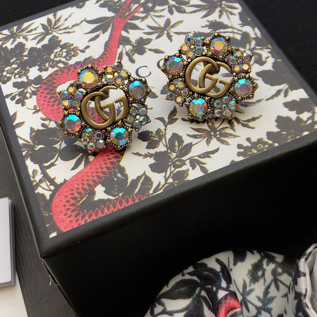 GUCCI 26S DOUBLE G LOGO MULTICOLOR CRYSTAL FLORAL STATEMENT STUD EARRINGS IN AGED GOLD TONE METAL 629028